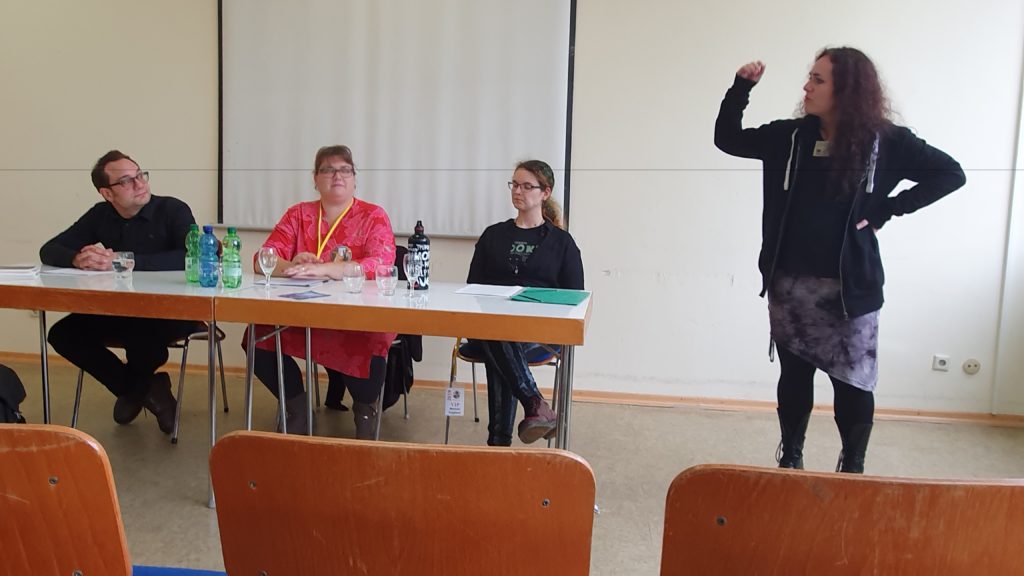 Lesung auf dem BuCon, drei Personen an einem Tisch, von links Robert von Cube, Veronika Lackerbauer, Melanie Vogltanz, daneben Verlegerin Ingrid Pointecker